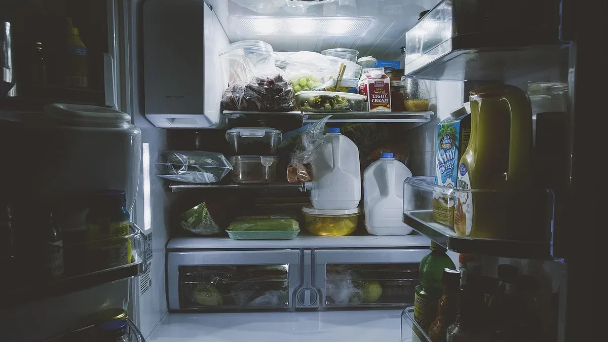 The interior of a refrigerator, with shelves stocked with various food items and containers.
